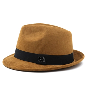 Detail of tan suede fedora hat featuring a black ribbon and silver metal letter M