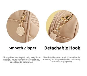 Detail of smooth metal zipper and detachable gold-tone hooks on beige crossbody bag