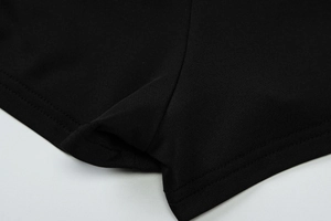 Détail du short en maille noire montrant des coutures renforcées à double aiguille de qualité