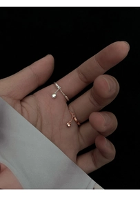 Detail of silver and rose gold adjustable chain rings with small bead pendants
