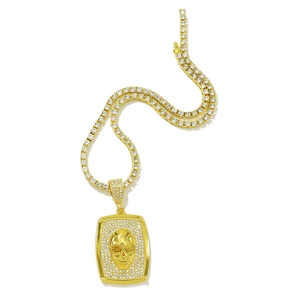 Collier hip hop doré avec pendentif crâne et chaîne sertie de cristaux sur fond blanc neutre