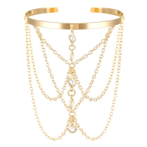 Detailed view of golden arm cuff with layered chains and sparkling crystal accents