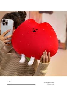 Mirror selfie showing a large strawberry plush toy pillow with cute facial expressions