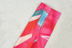 Detail of thumbhole cuffs and colorful abstract print on long sleeve mini dress