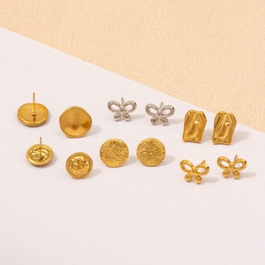 Macro shot of 304 stainless steel bow and geometric stud earrings set in gold and silver