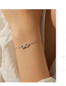 Detail of S925 silver infinity bracelet with sparkling moissanite on a female wrist