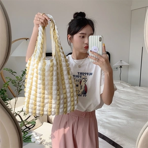 Close-up of yellow and white bubble textured tote bag made of wrinkled fabric in a casual mirror selfie