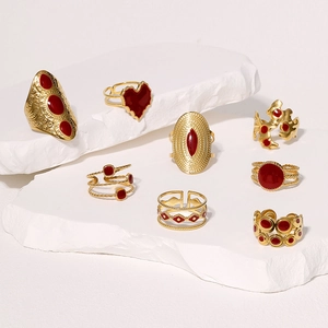 Retro gold stainless steel open rings with red enamel hearts on elegant stone display