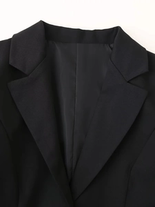 Détail de la robe blazer noire avec col à revers élégant et texture tissée fine