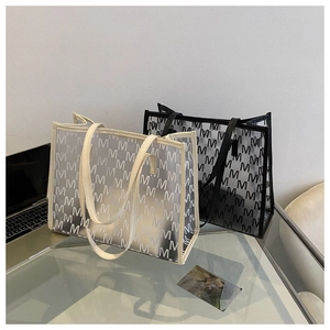 Detailed view of two large capacity tote bags with M-pattern print in black and cream