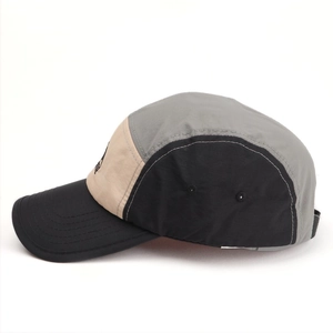 Detail of multi-color five-panel camper hat featuring quick-dry nylon and breathable eyelets
