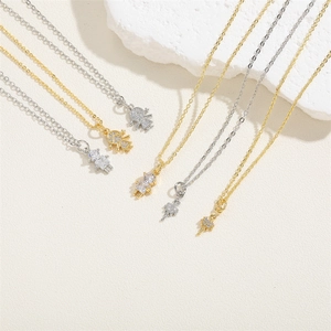 Ballerina zircon pendant necklaces in gold and silver tones on a textured stone base