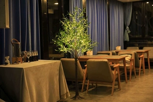 Detailed view of warm yellow LED olive tree lights in a restaurant setting