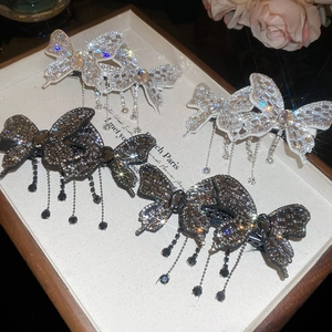 Close-up of butterfly hair clips with sparkling rhinestone tassels in a luxury tray