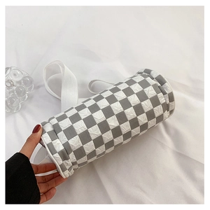 Detail of checkered cylinder crossbody bag with textured fabric and wide shoulder strap