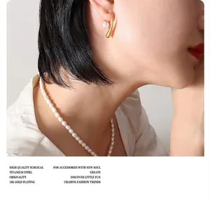 Detail of 18K gold plated surgical titanium steel earring with white pearl on model