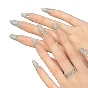Elegant long almond press-on nails with nude base, silver glitter, and rhinestones