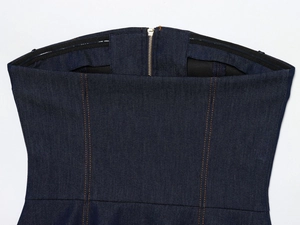 Détail du haut bustier en denim bleu foncé avec fermeture éclair dorée et bande silicone