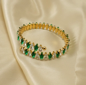 Detail of 18K gold stainless steel bangle with green and white marquise-cut zircons