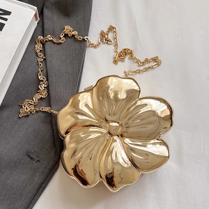 Detailed view of flower-shaped golden metallic evening clutch with a fine chain strap