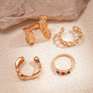 Set of four gold-plated irregular geometric rings with colorful rhinestones and chain design