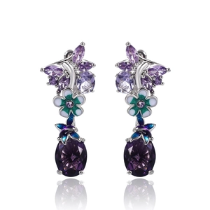 Close-up of silver butterfly flower earrings with purple and green zircon gems