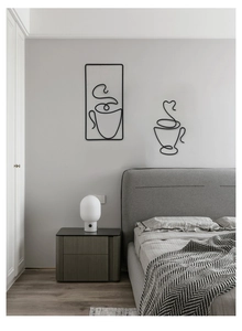 Detail view of abstract black metal wire wall art featuring creative coffee cup outlines