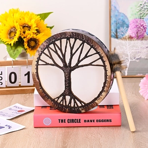 Siberian shaman drum with Tree of Life design on red books with drumstick