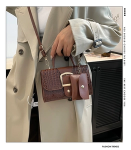 Gros plan du sac à main marron à motif crocodile avec petite pochette assortie