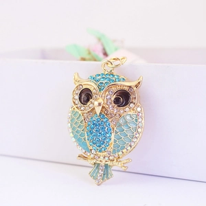 Golden owl keychain with blue rhinestones and enamel wings on a branch base