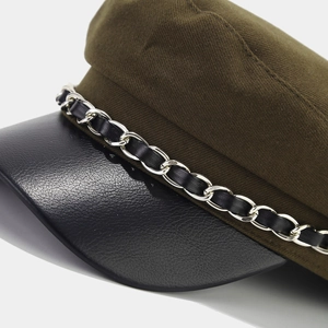 Olive green newsboy cap with black leather visor and decorative silver chain detail