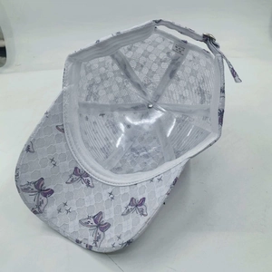 Detail view of white lace baseball cap featuring breathable mesh and purple butterfly embroidery