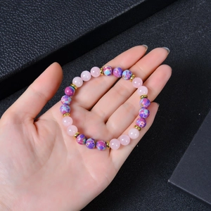 Pink quartz and emperor stone beaded bracelet with gold spacers on black box