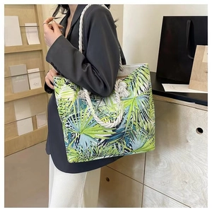 Close-up of canvas tote bag featuring tropical palm leaf print and thick rope handles