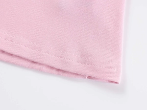 Detailed close-up of double-needle stitching on the hem of pink V-neck ribbed T-shirt