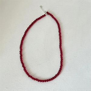 Close-up of red agate beaded necklace with silver lobster clasp and heart pendant
