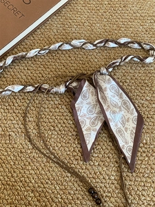 Détail d'une ceinture écharpe bohème avec motif paisley, perles en bois et textures tissées