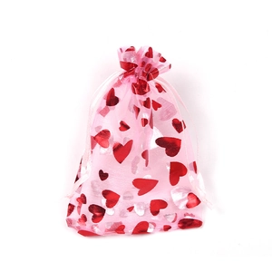 Pink organza drawstring gift bag featuring shiny red foil heart patterns on white background