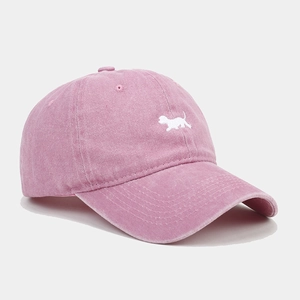 Détail d'une casquette de baseball rose délavée avec broderie chiot et visière courbée