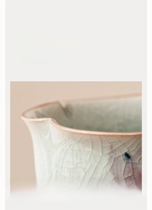 Vue macro d'une tasse à thé en céramique céladon avec glaçure craquelée et bord ondulé