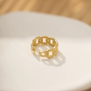Detailweergave van een vintage gouden schakelring op een witte minimalistische stand