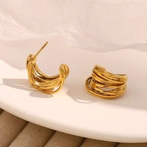 Vista macro di orecchini a perno in acciaio placcato oro 18K con design a C traforato