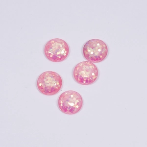Macro detail of five round pink resin gems with iridescent glitter for DIY jewelry making