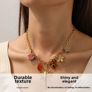 Close-up of heart-shaped leopard print and golden sun pendants on a layered necklace