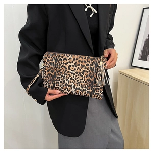Close-up of stylish leopard print clutch bag with fringe tassel detail and zipper closure