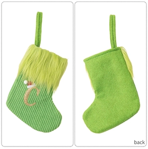 Detail of green knit Christmas stocking featuring gold letter C and soft faux fur trim
