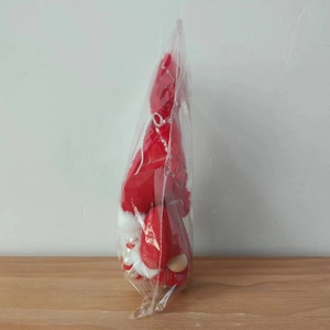 Close-up of Valentine gnome plush with sequined hat and pearl legs in OPP packaging