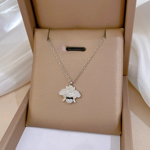 Détail macro d'un pendentif abeille argenté avec cristaux dans un coffret à bijoux