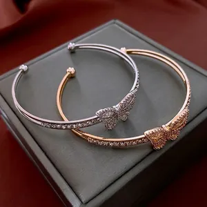 Gold and silver butterfly open bracelets with sparkling cubic zirconia on jewelry box