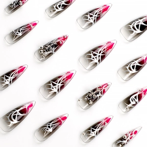 Dark stiletto press-on nails with grey gradient, pink ink art and 3D metal crosses